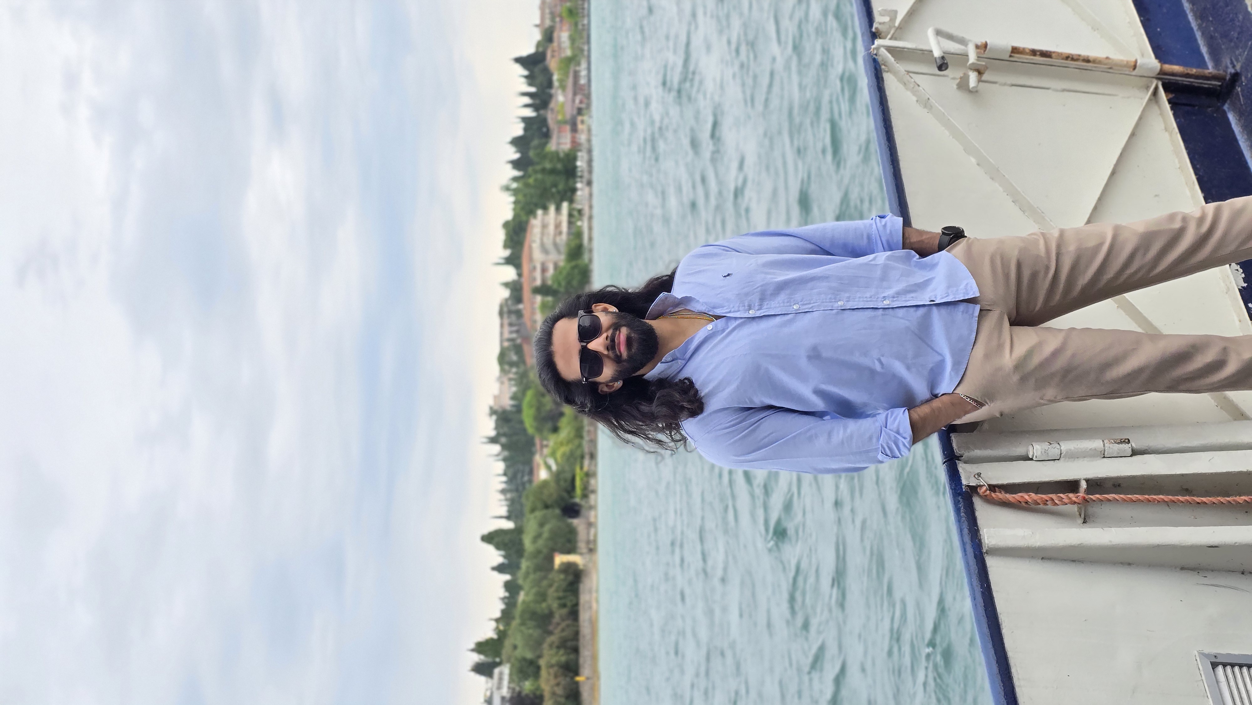 Rizwan Mahmood on a boat, sunglasses on, with the city skyline behind him